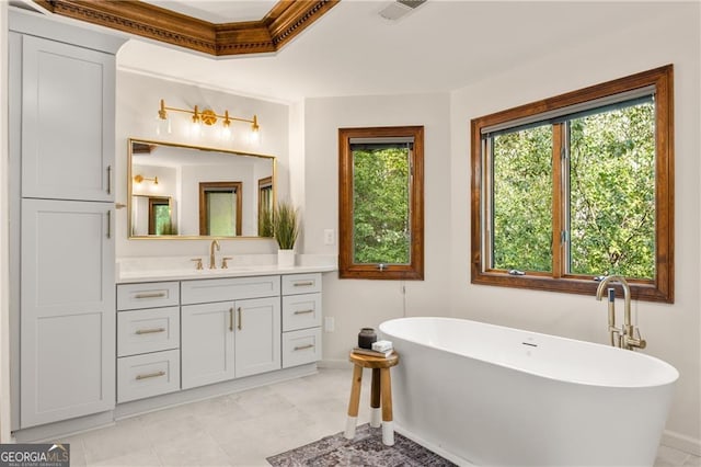 bathroom with a tub to relax in, tile patterned flooring, and vanity