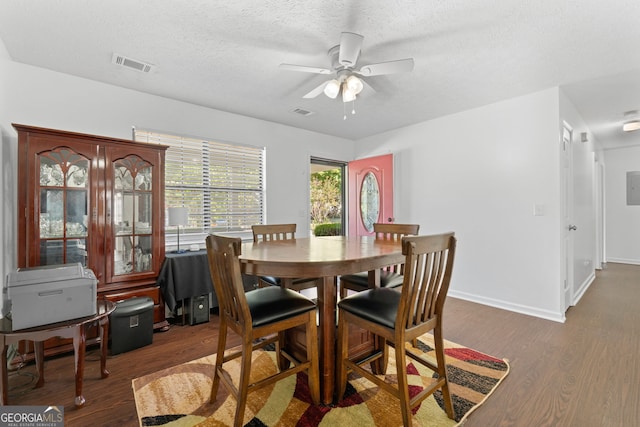 dining room featuring a textured ceiling, dark hardwood / wood-style floors, and ceiling fan