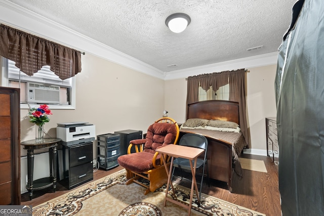 living area with wood-type flooring, cooling unit, a textured ceiling, and crown molding