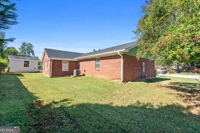 back of property featuring a lawn and central AC