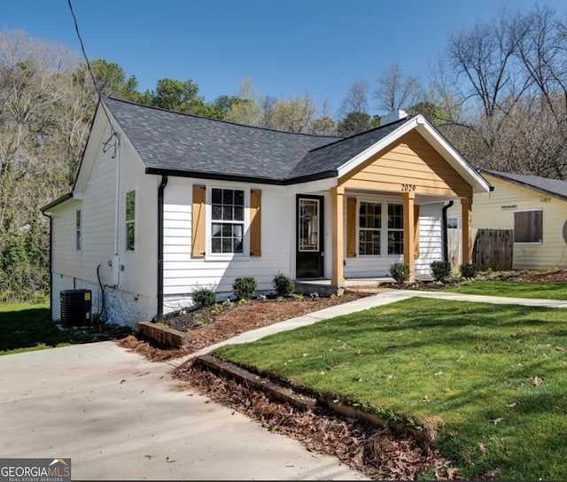 view of front facade with cooling unit and a front yard