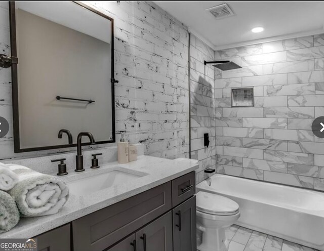 full bathroom with tiled shower / bath combo, vanity, and toilet