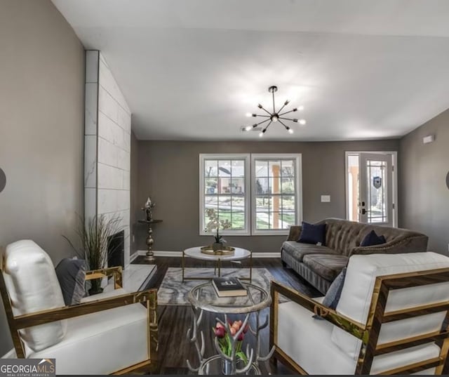 living room with hardwood / wood-style flooring, lofted ceiling, and a notable chandelier