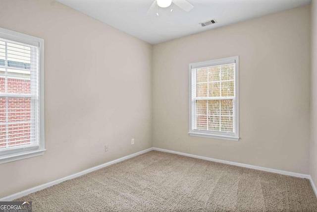 carpeted spare room featuring plenty of natural light