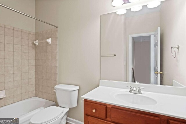 full bathroom with tiled shower / bath, vanity, and toilet