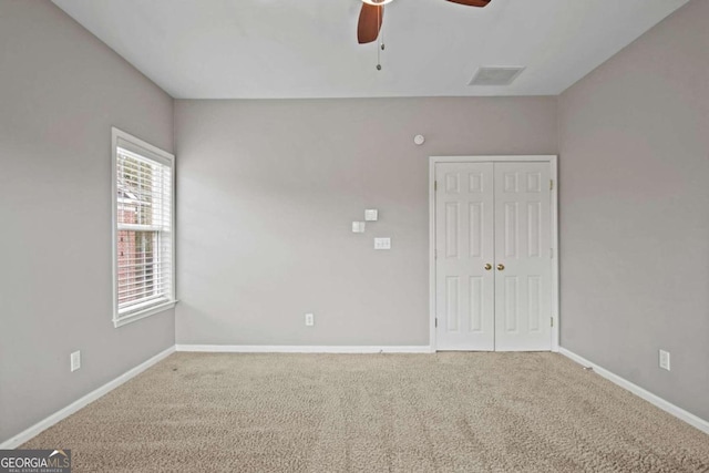 spare room with carpet floors and ceiling fan