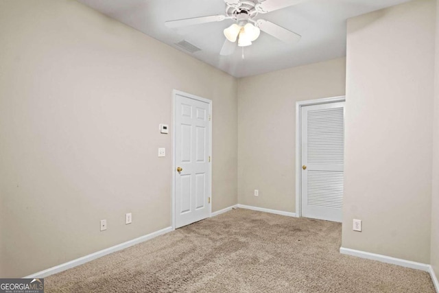 carpeted spare room featuring ceiling fan