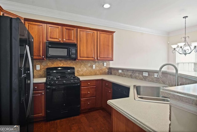 kitchen featuring dark hardwood / wood-style floors, sink, a notable chandelier, hanging light fixtures, and black appliances