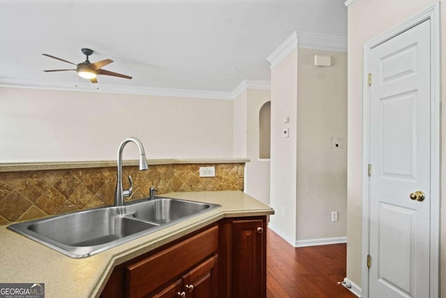 kitchen featuring tasteful backsplash, dark hardwood / wood-style flooring, crown molding, ceiling fan, and sink