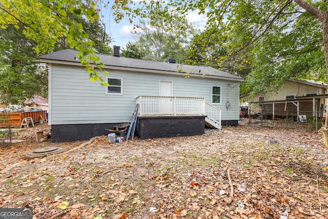 rear view of property featuring a wooden deck