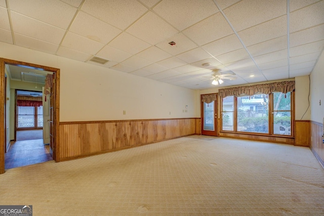 spare room featuring a drop ceiling, ceiling fan, and light colored carpet