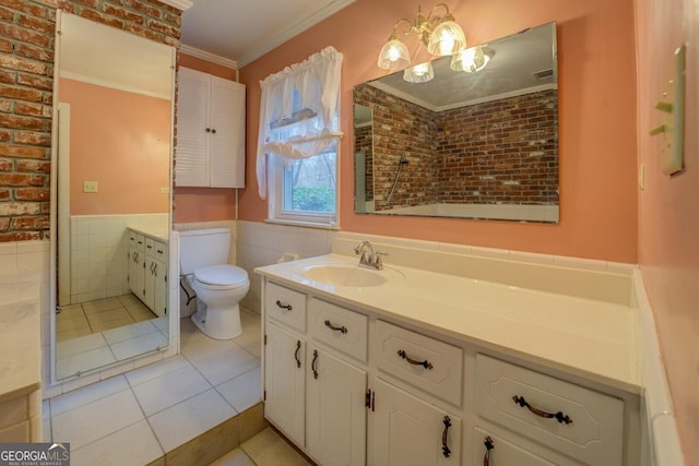 bathroom featuring tile patterned floors, vanity, crown molding, tile walls, and toilet