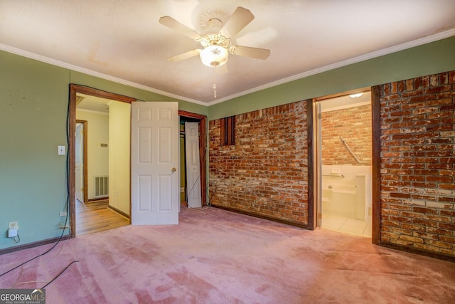 unfurnished bedroom with connected bathroom, ceiling fan, brick wall, crown molding, and light carpet