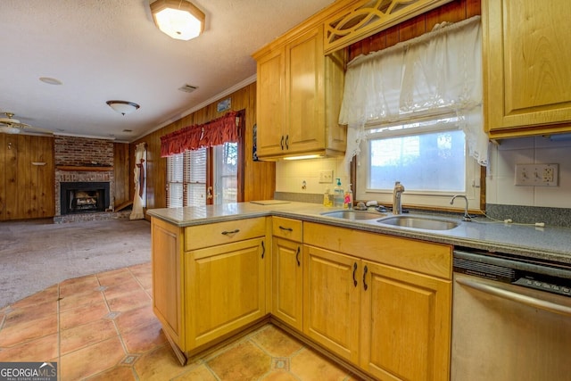 kitchen featuring sink, stainless steel dishwasher, light carpet, a fireplace, and ornamental molding