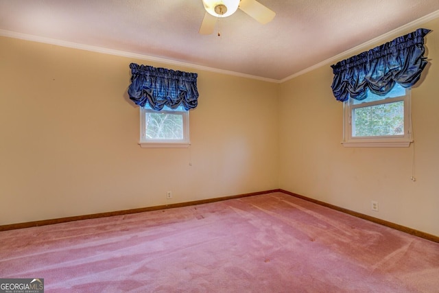 carpeted empty room with a wealth of natural light, ceiling fan, and ornamental molding