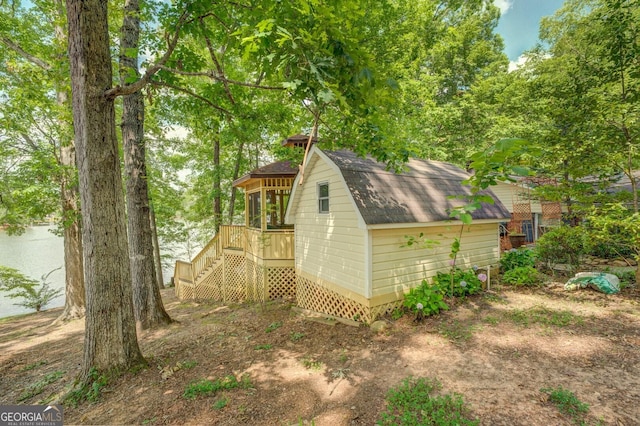 view of side of home featuring a deck and a storage shed