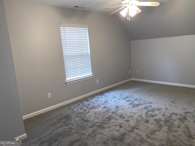 additional living space featuring lofted ceiling, dark colored carpet, and ceiling fan