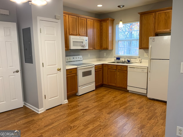 kitchen featuring electric panel, sink, light hardwood / wood-style flooring, white appliances, and decorative light fixtures