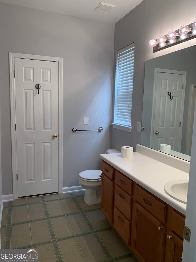 bathroom featuring tile patterned flooring, vanity, and toilet