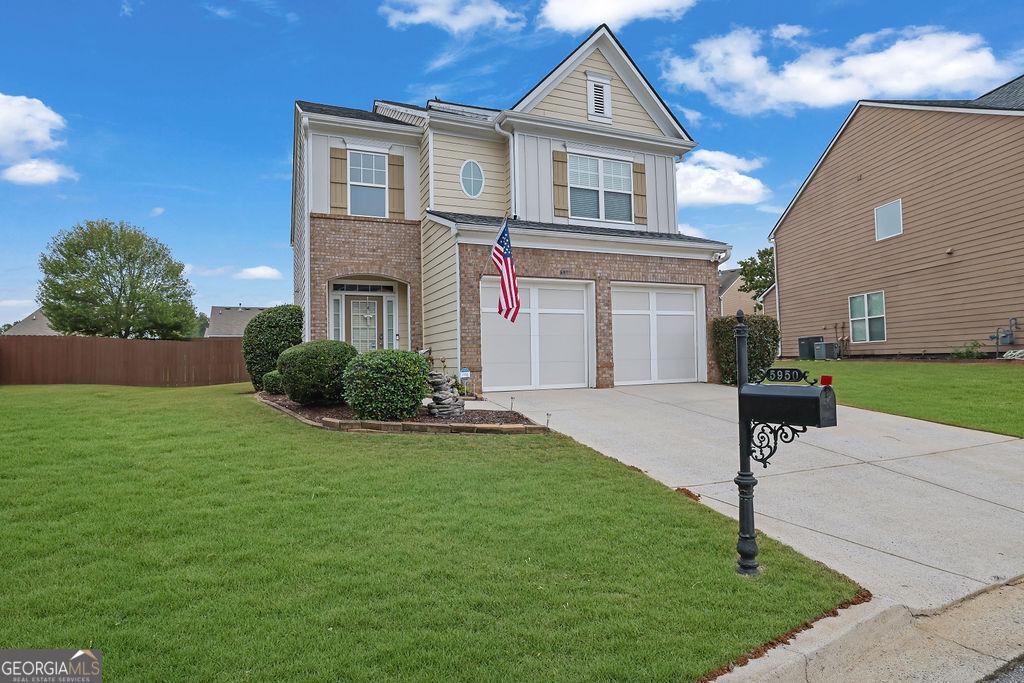 view of front of property with central AC unit, a garage, and a front lawn