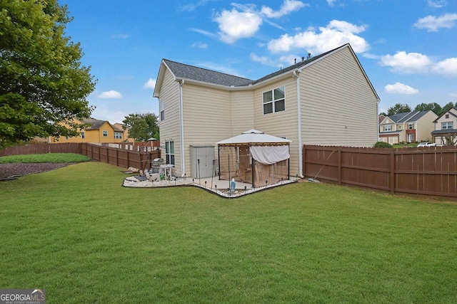 rear view of property featuring a gazebo, a patio, and a lawn