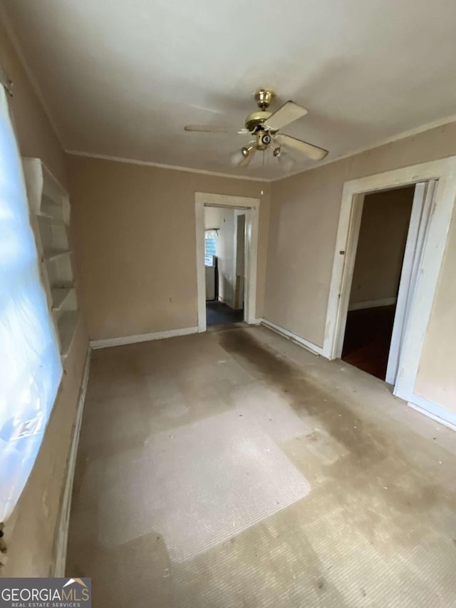 spare room with ornamental molding and ceiling fan