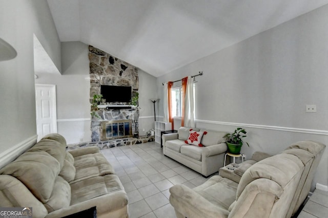 tiled living room with vaulted ceiling and a stone fireplace