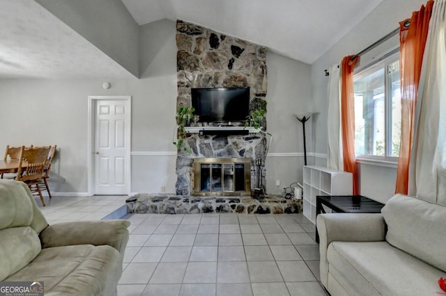 tiled living room featuring a stone fireplace and vaulted ceiling