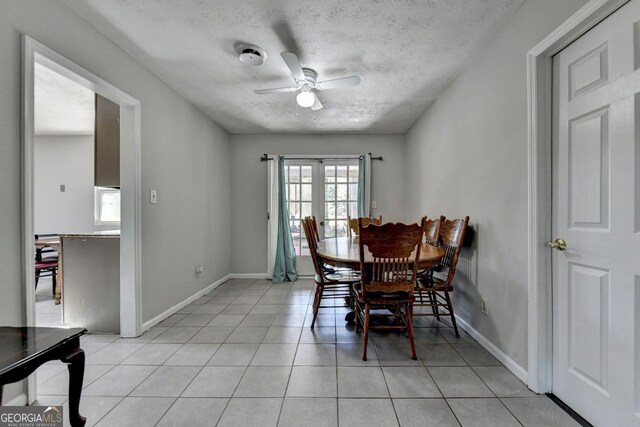 tiled dining room with a textured ceiling and ceiling fan