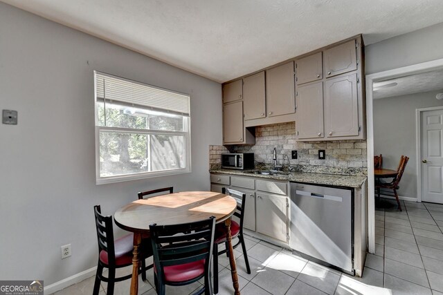 kitchen with light tile patterned floors, tasteful backsplash, appliances with stainless steel finishes, and sink