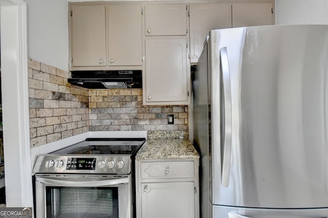 kitchen with light stone countertops, backsplash, white cabinetry, stainless steel appliances, and extractor fan