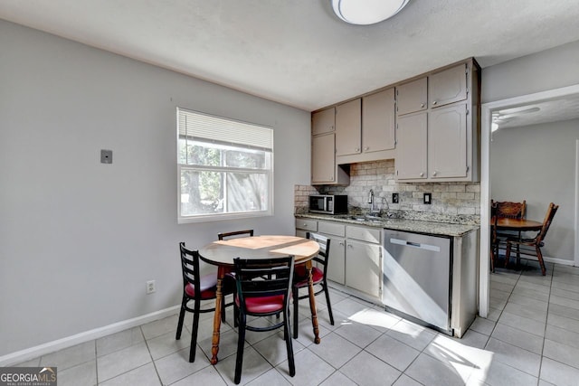 kitchen featuring gray cabinets, decorative backsplash, light tile patterned flooring, and stainless steel appliances