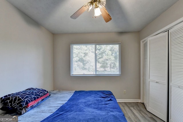 bedroom with a closet, ceiling fan, a textured ceiling, and light wood-type flooring