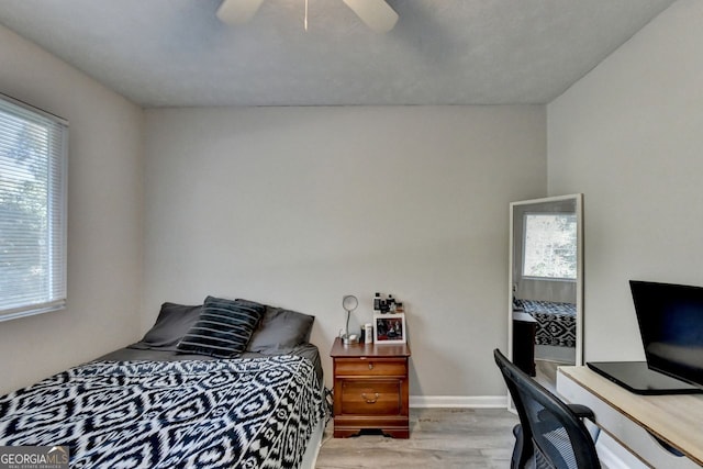 bedroom featuring light hardwood / wood-style flooring, multiple windows, and ceiling fan