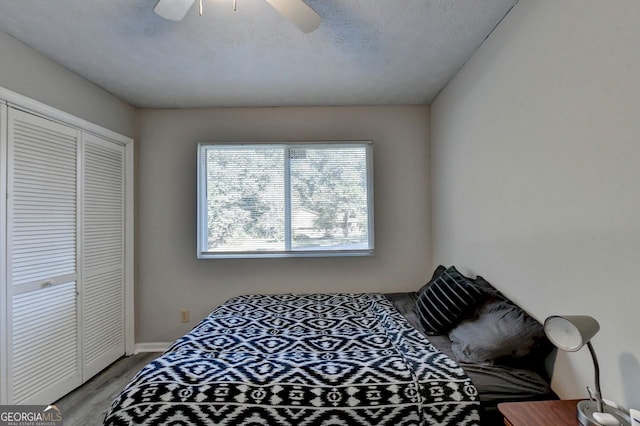 bedroom featuring a closet, a textured ceiling, light wood-type flooring, and ceiling fan