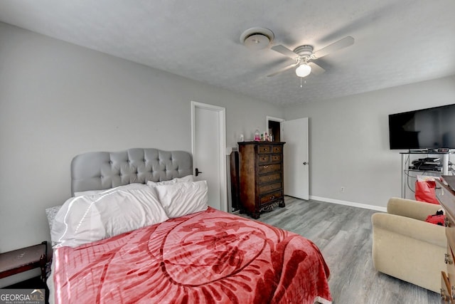 bedroom featuring light hardwood / wood-style flooring, a textured ceiling, and ceiling fan