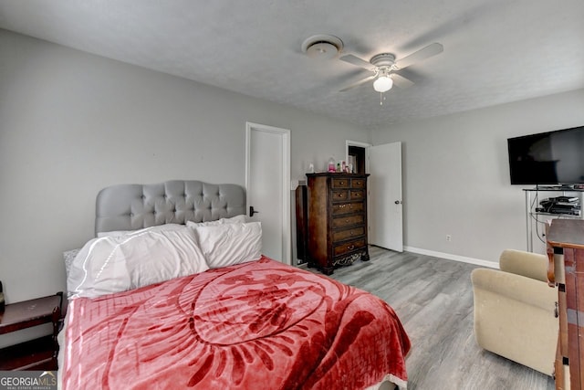 bedroom with light hardwood / wood-style flooring, a textured ceiling, and ceiling fan