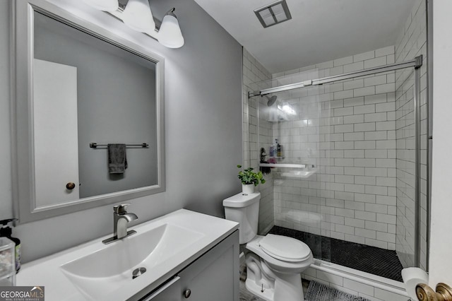 bathroom featuring vanity, toilet, and an enclosed shower