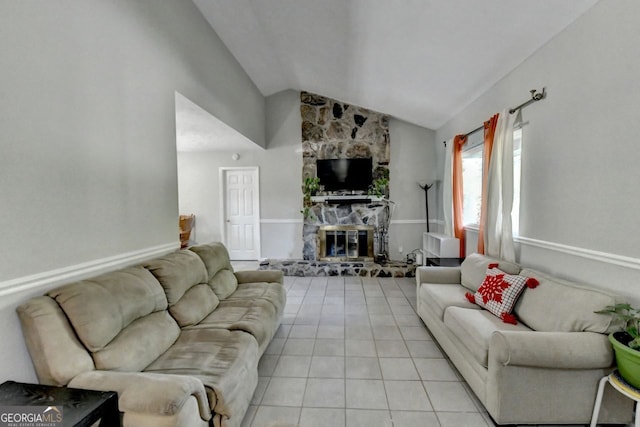 tiled living room featuring a stone fireplace and lofted ceiling