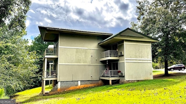 view of side of home featuring a balcony and a yard