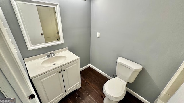 bathroom featuring toilet, vanity, and hardwood / wood-style floors