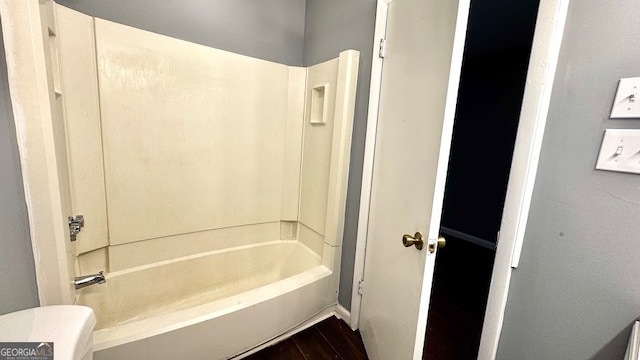 bathroom with shower / tub combination, hardwood / wood-style flooring, and toilet