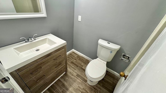 bathroom with hardwood / wood-style flooring, vanity, and toilet