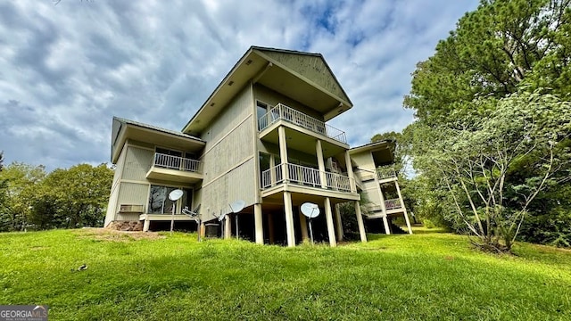 back of property featuring a balcony and a yard