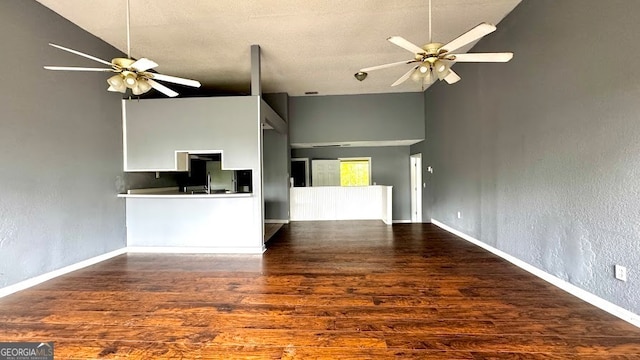 unfurnished living room featuring ceiling fan, dark hardwood / wood-style floors, and high vaulted ceiling