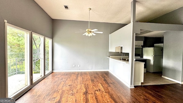 kitchen with high vaulted ceiling, hardwood / wood-style floors, ceiling fan, and white refrigerator