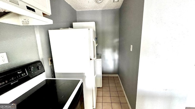 kitchen with black / electric stove, white fridge, a textured ceiling, extractor fan, and tile patterned floors