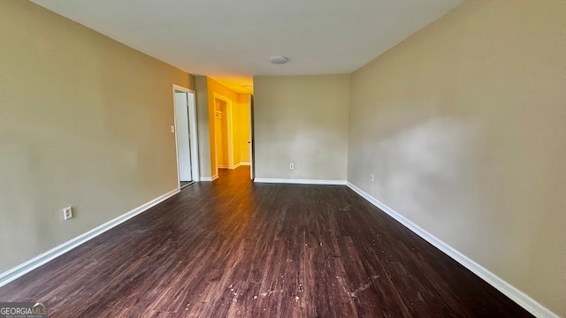 unfurnished room with dark hardwood / wood-style flooring