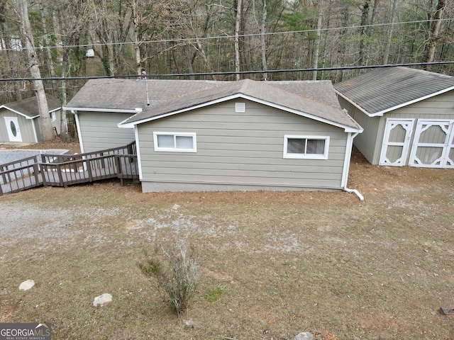 view of home's exterior featuring a shed and a wooden deck