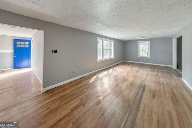 empty room featuring a textured ceiling and light hardwood / wood-style floors